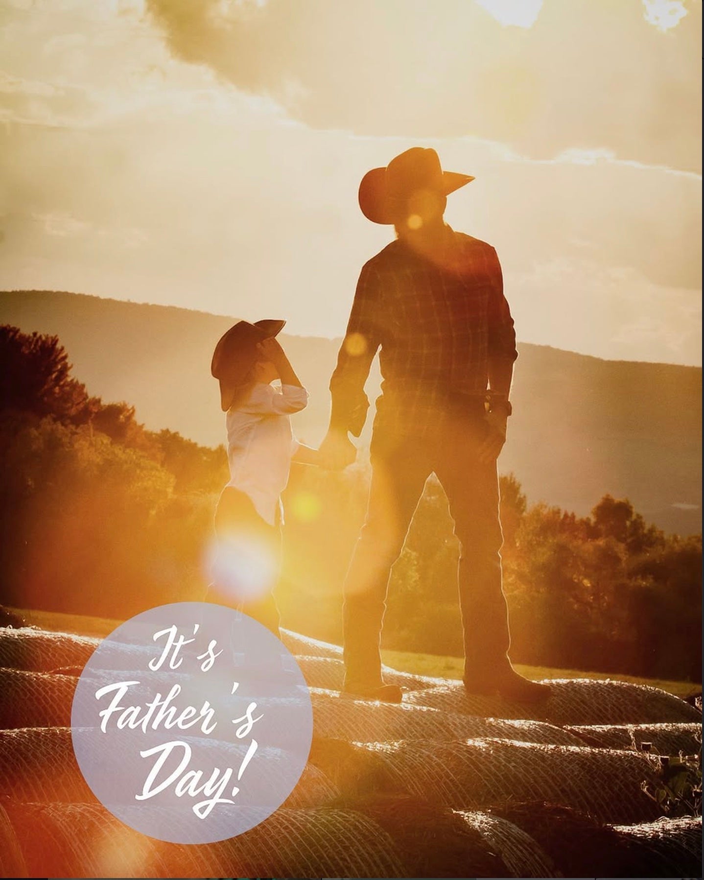Kevin and his son standing together on the Cider Creek family farm at sunset